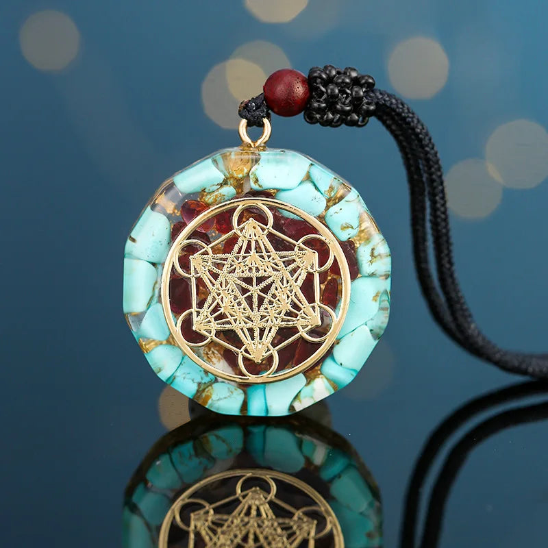 Turquoise pendant with gold geometric design on a black cord against a blue background