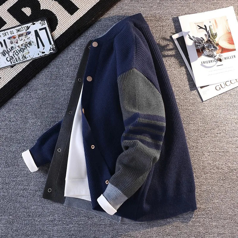 Navy blue cardigan with gray sleeves on a textured surface