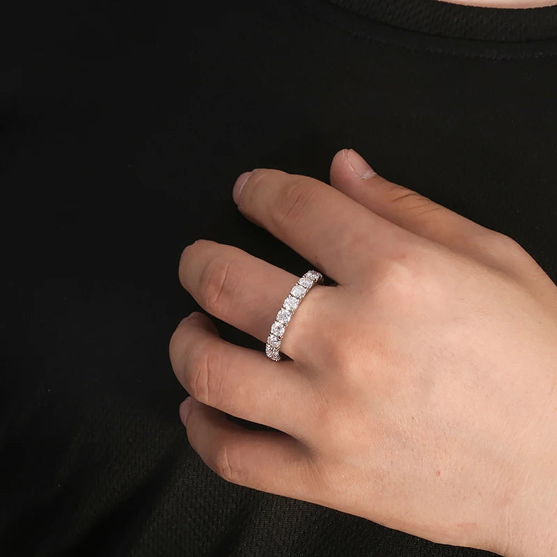 Hand wearing a diamond ring on a black background