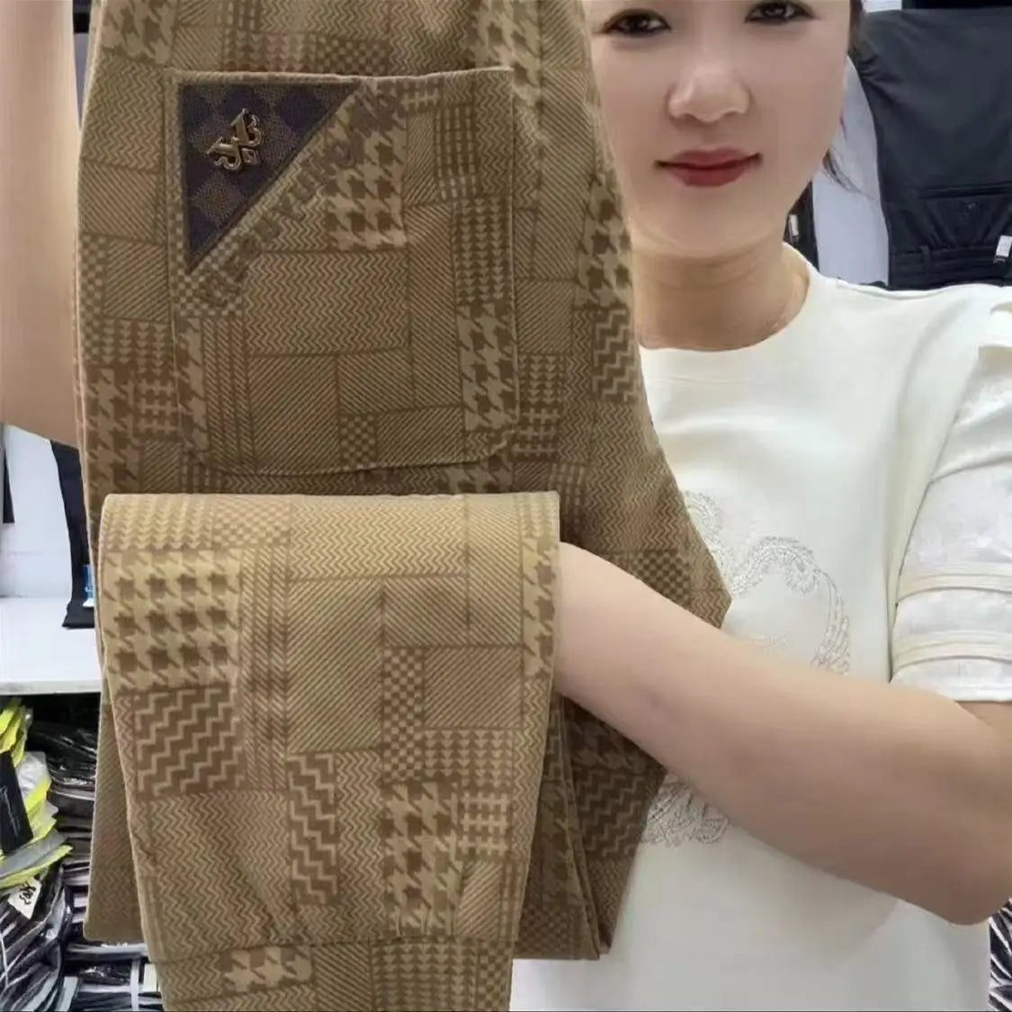 Person holding a brown textured fabric with a geometric pattern