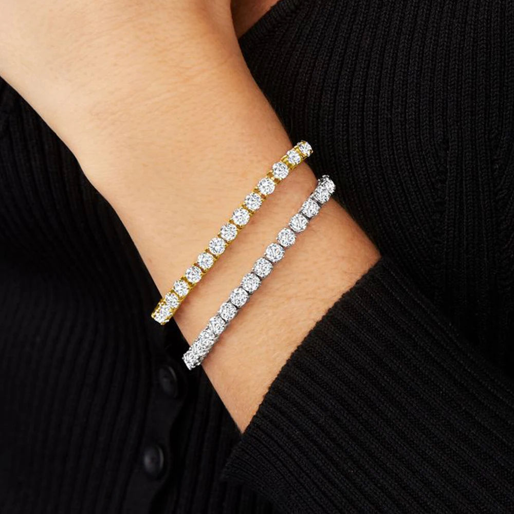 Two diamond bracelets on a person's wrist against a black background