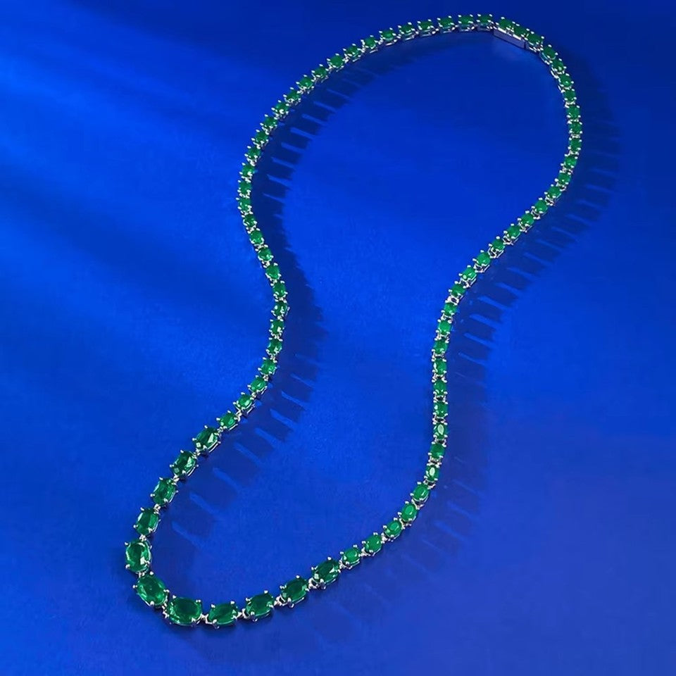 925 Sterling Silver Oval Cut Emerald Tennis Necklace detail shot on blue velvet background