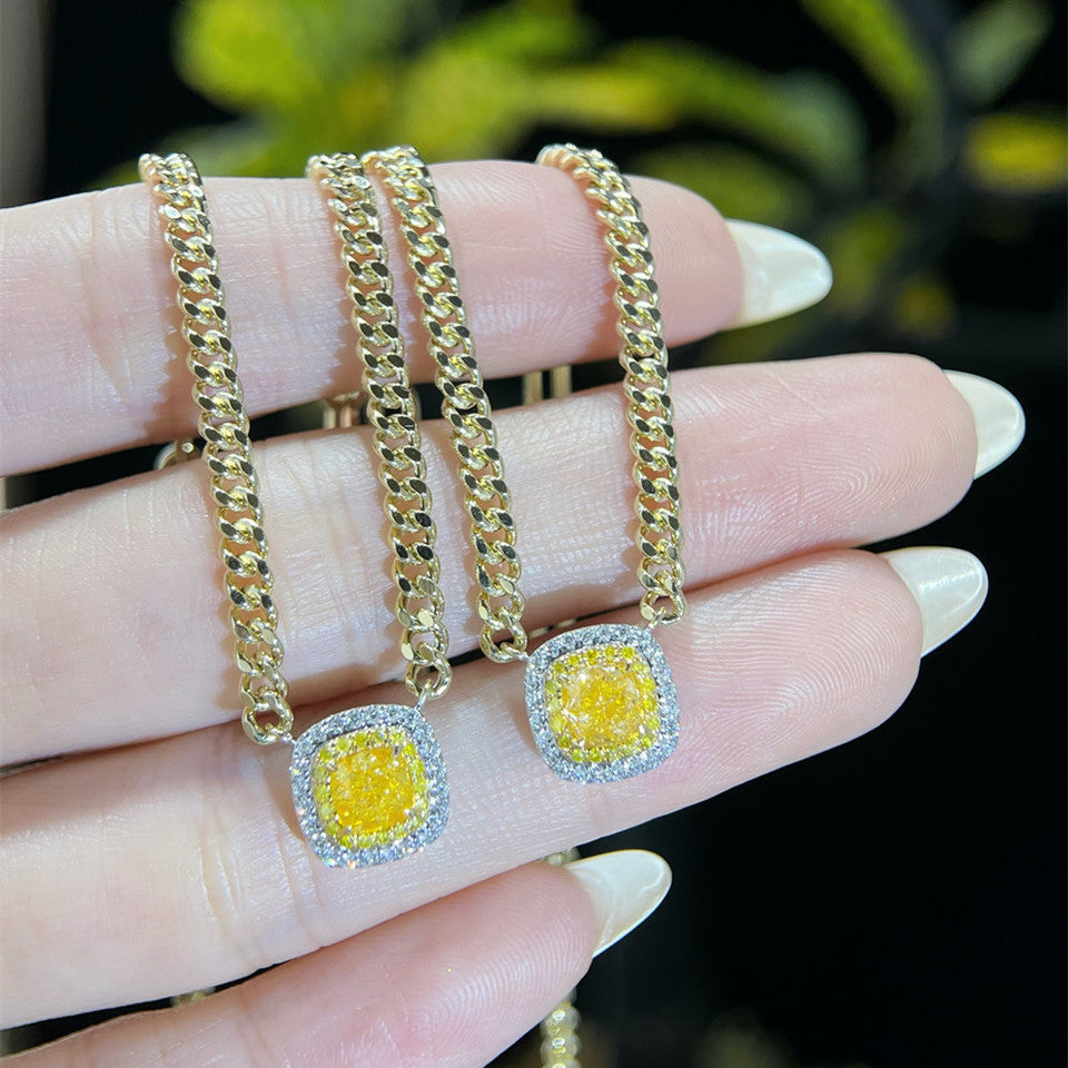 18K yellow gold Cuban link necklace with yellow diamond pendant on black velvet display