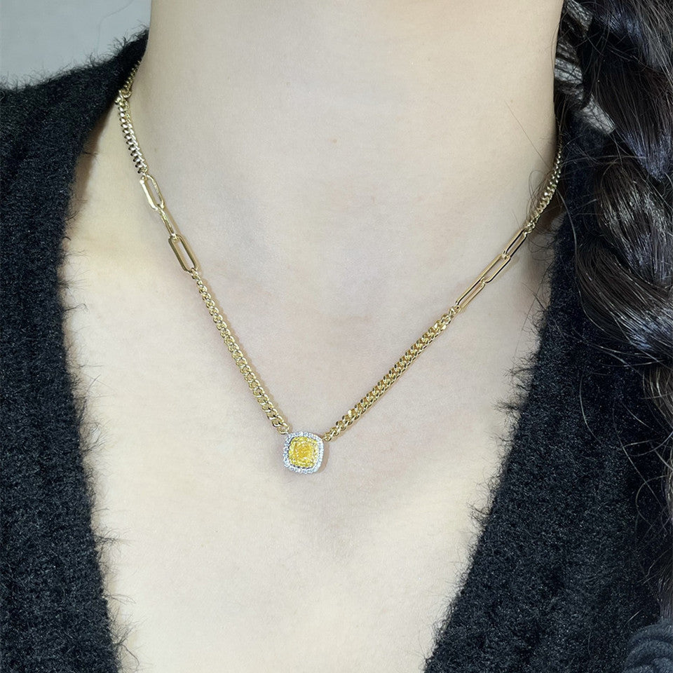 18K yellow gold Cuban link necklace with yellow diamond pendant worn on neck close-up