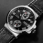 Luxury watch with black dial and leather strap on a dark background