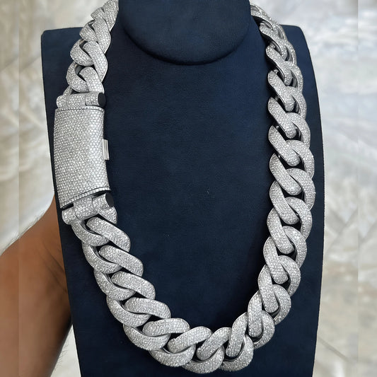 Silver chain necklace on a black stand with a blurred background