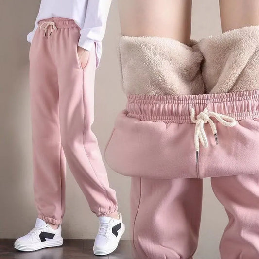 Pink sweatpants worn by a person with a neutral background
