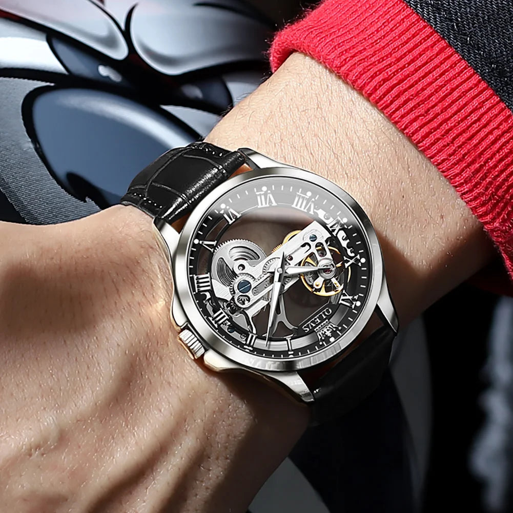 Luxury watch with black strap and silver case on a wrist, blurred background