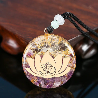 Crystal pendant with lotus flower and Om symbol on a wooden surface