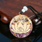 Crystal pendant with lotus flower and Om symbol on a wooden surface