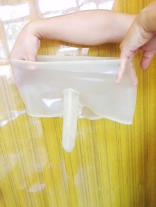 Person holding a clear plastic bag with a white object inside on a yellow background
