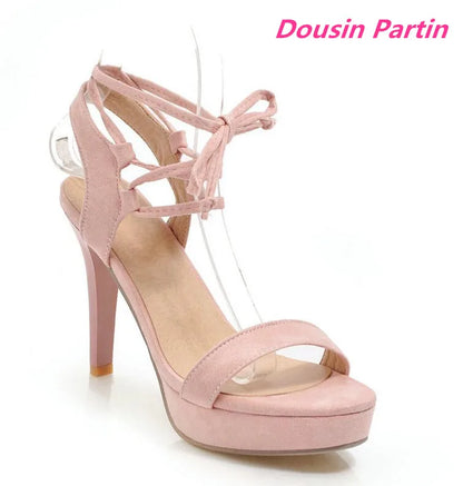 Pink high-heeled sandal with strappy design on a white background, featuring the brand 'Dousin Partin'.