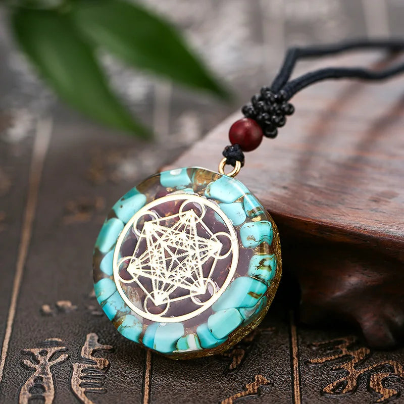 Turquoise pendant with gold design on a wooden surface