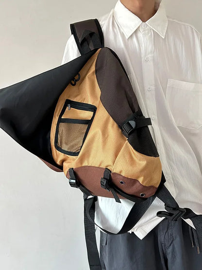 Person wearing a beige sling bag with black straps on a plain background