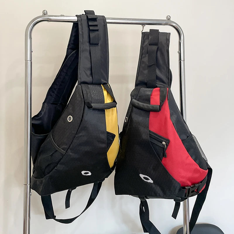 Two backpacks, one black with yellow interior and the other black with red interior, hanging on a metal rack against a white wall.