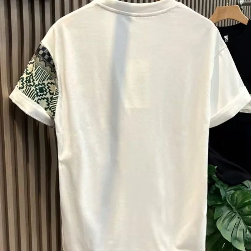 White t-shirt with patterned sleeves on a hanger against a neutral background