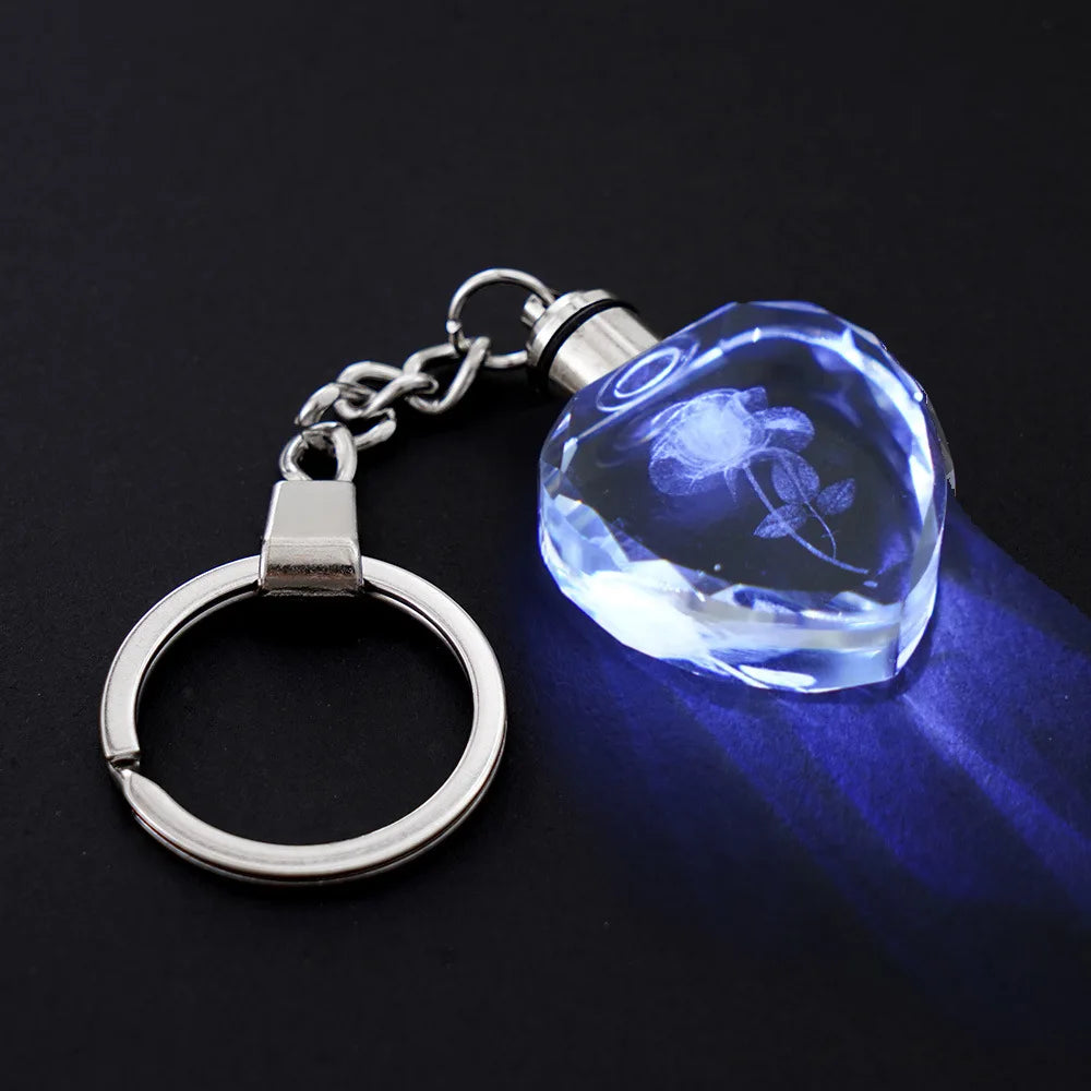 Keychain with a crystal pendant featuring an engraved design on a dark background