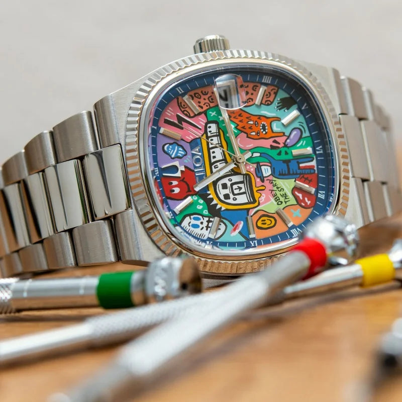 Colorful watch face with cartoon characters on a metallic watch, placed on a wooden surface.