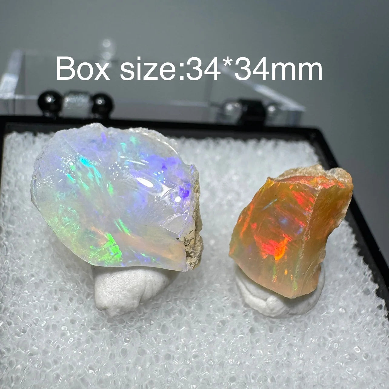 Two colorful opal stones in a box with dimensions 34*34mm.