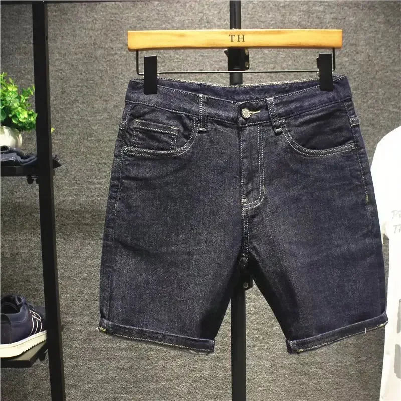Denim shorts on a hanger against a neutral background