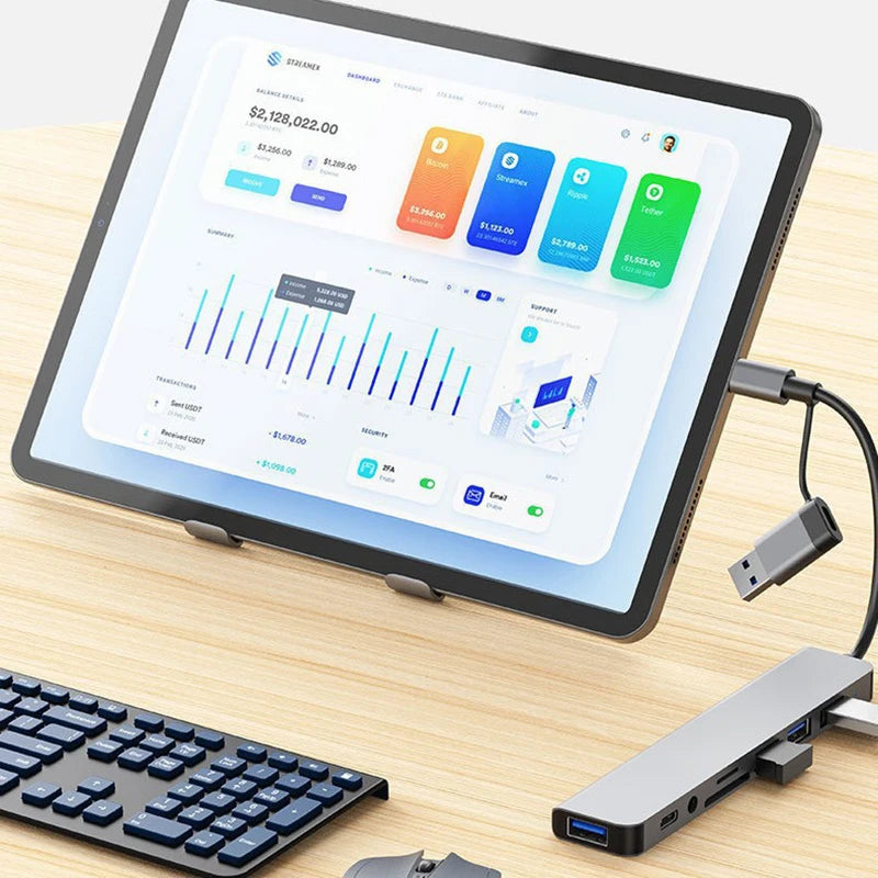 Tablet on a stand with a keyboard and USB hub on a wooden surface