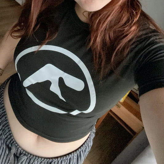 Person wearing a black t-shirt with a white logo indoors