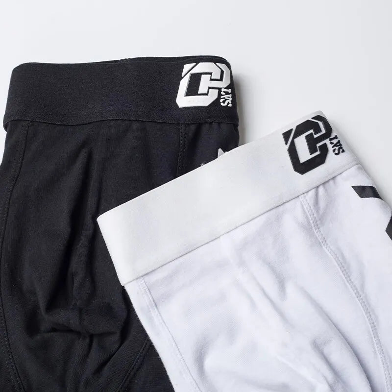 Black and white shorts with a brand logo on a light gray background