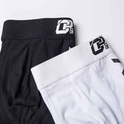 Black and white shorts with a brand logo on a light gray background