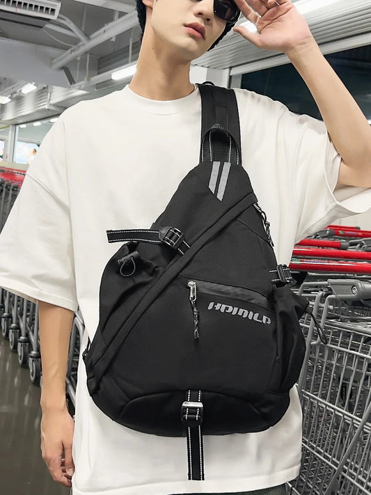 Person wearing a black sling bag with a visible brand logo in an indoor setting.