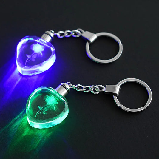 Two LED keychains with floral designs on a dark background