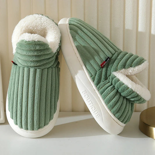 Green slippers with white fur lining on a light background