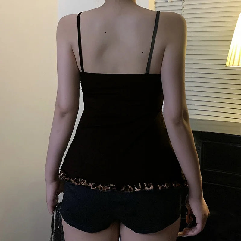 Person wearing a black tank top with thin straps and leopard print trim.