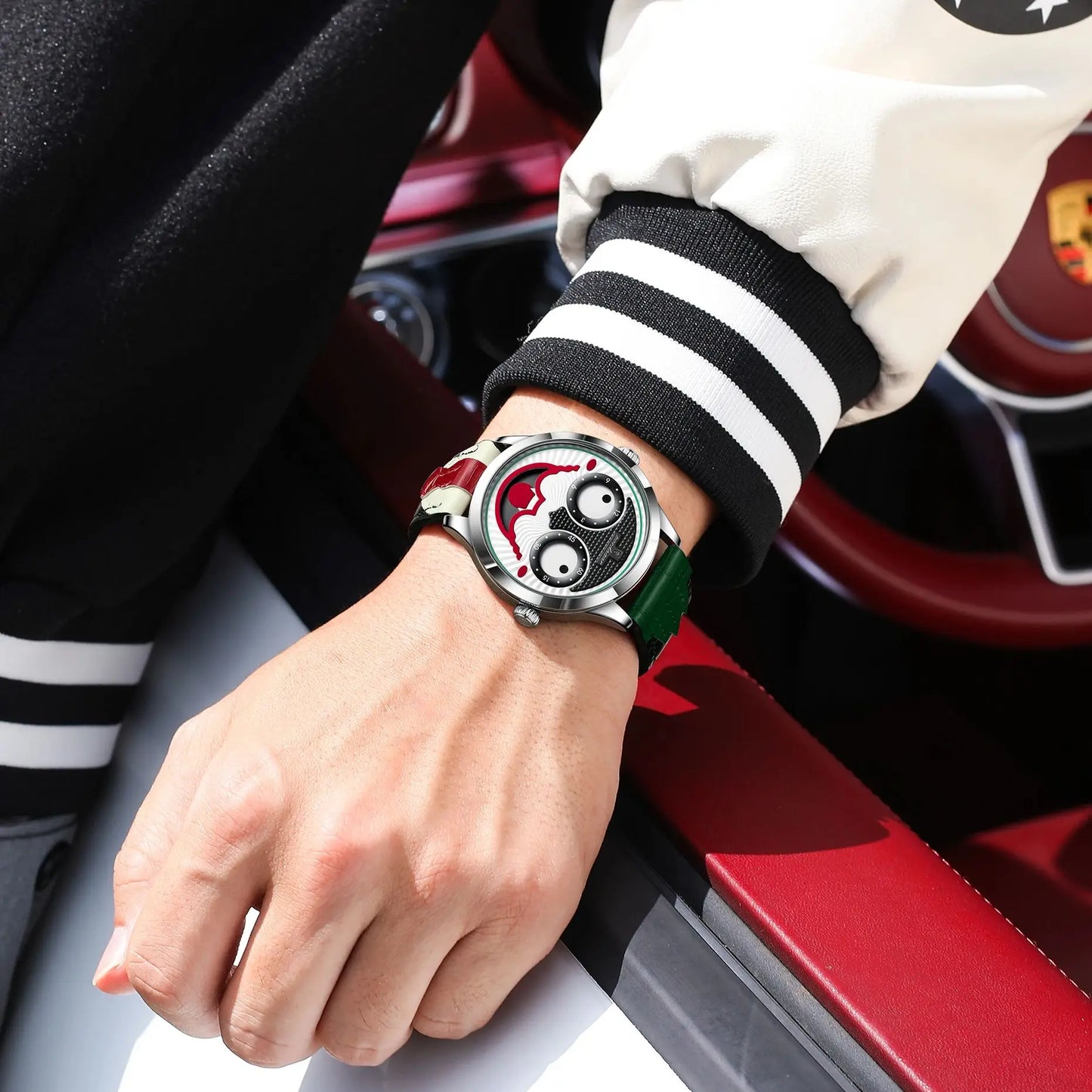 Person wearing a watch with a unique design, sitting inside a red vehicle.