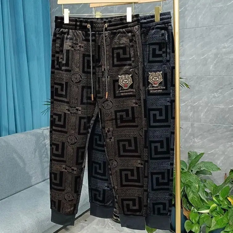 Patterned pants with brand logo on a stand against a gray wall.