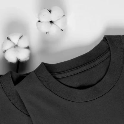 Close-up of a black turtleneck sweater with cotton bolls in the background