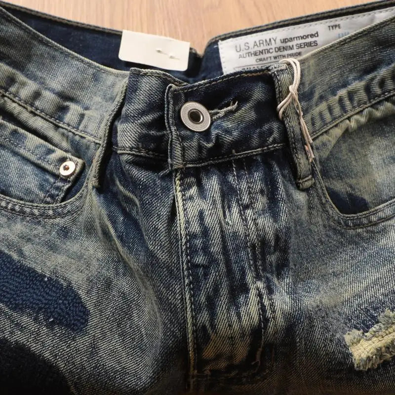 Close-up of a pair of blue jeans with a U.S. Army label on a wooden surface.