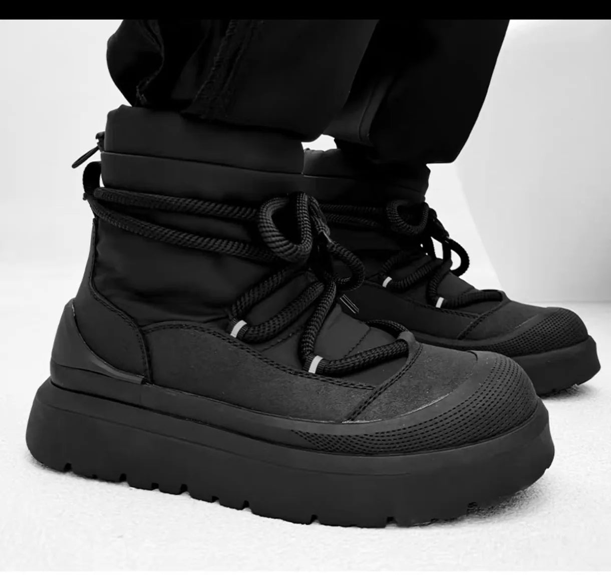 Black winter boots on a white background