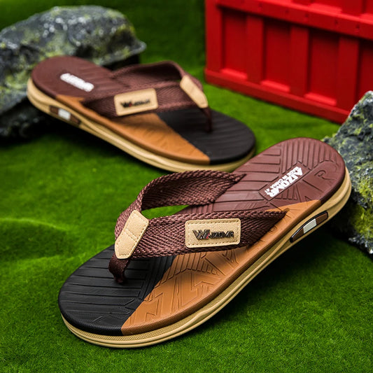 Brown and black sandals with a visible brand logo on a grassy background