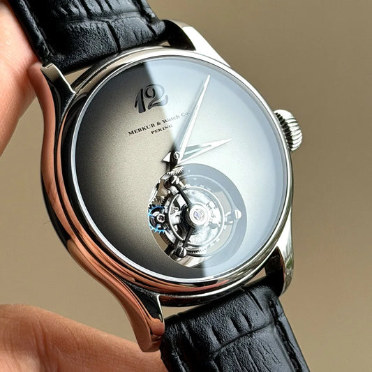 Luxury watch with black leather strap and visible brand logo on beige background