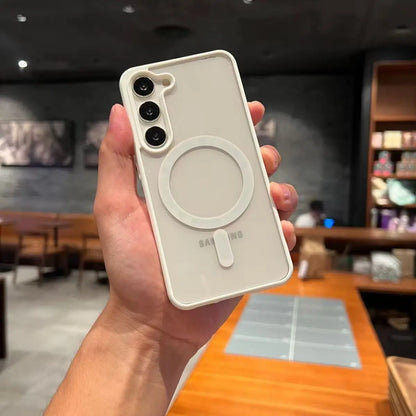 Hand holding a Samsung phone with a white case in an indoor setting