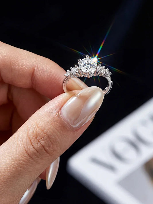 Diamond ring held between fingers with a blurred background