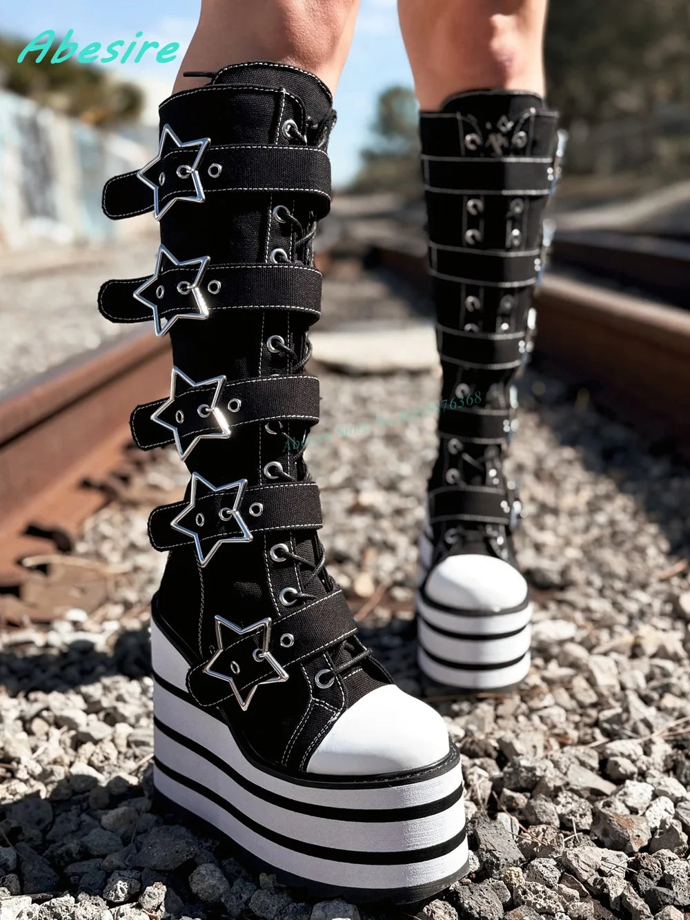 Black platform boots with star designs on a gravel surface