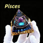 Triangular crystal with astrological design labeled 'Pisces' held by a gloved hand against a black background.