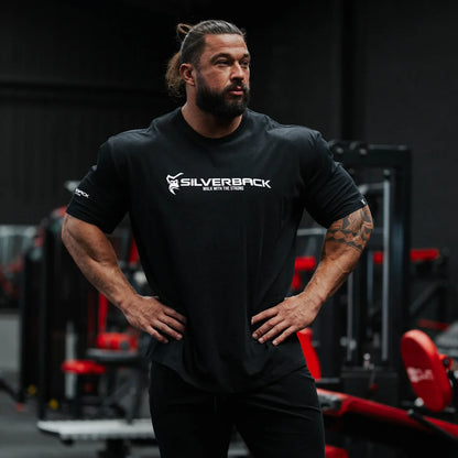 Man wearing a black 'Silverback' t-shirt in a gym setting