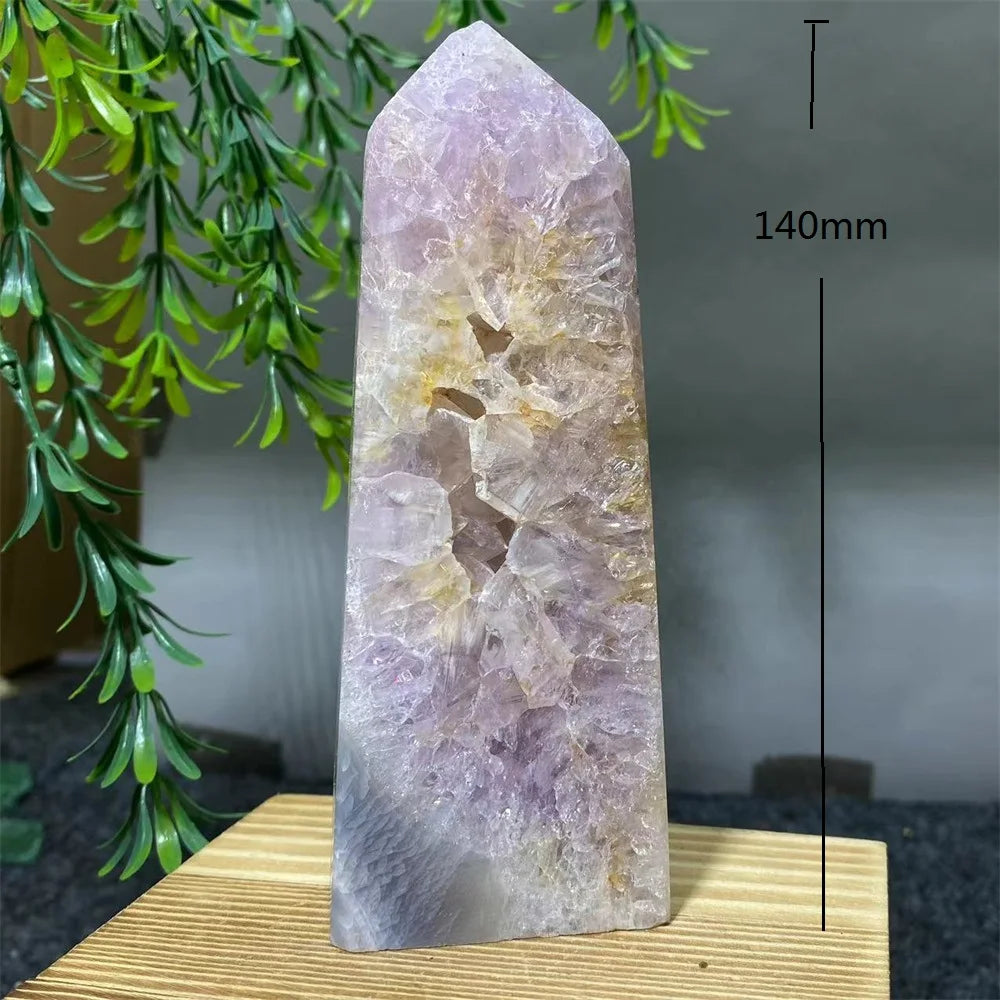 Crystal tower with measurement label on a wooden stand against a natural background