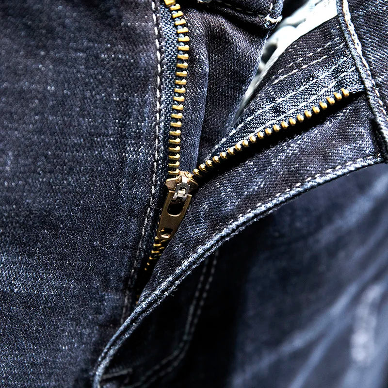Close-up of a dark denim jacket with a gold zipper