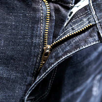 Close-up of a dark denim jacket with a gold zipper