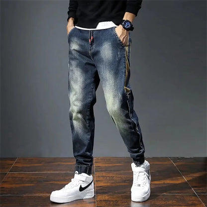 Person wearing blue jeans and white sneakers on a gray background