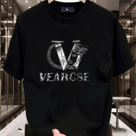 Black t-shirt with a silver logo and text held in front of a reflective surface.