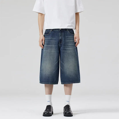 Person wearing blue denim shorts and a white t-shirt on a plain background